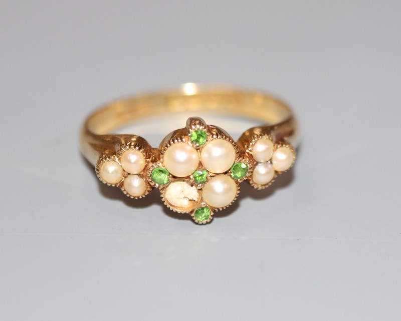 An Edwardian 18ct gold, split pearl and demantoid garnet cluster set dress ring, size P/Q, gross 3.9 grams.